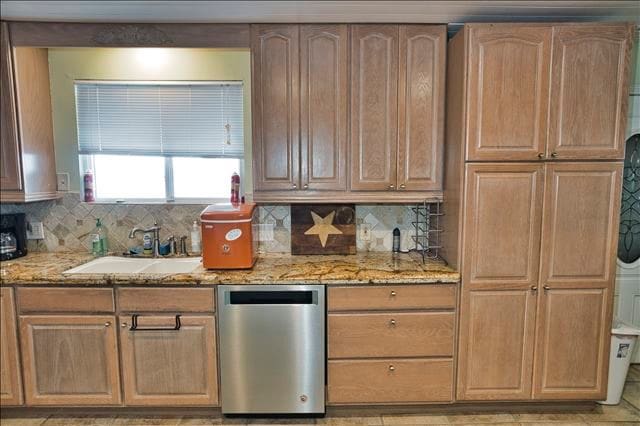 kitchen with dishwasher, light stone countertops, sink, and backsplash