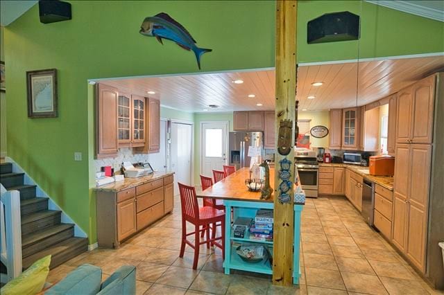 kitchen featuring light brown cabinets, light tile patterned floors, wooden ceiling, and stainless steel appliances