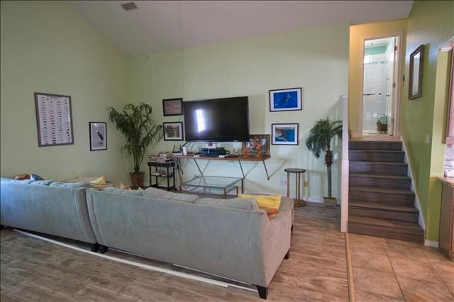 living room with light wood-type flooring and vaulted ceiling