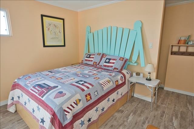 bedroom with light wood-type flooring and ornamental molding