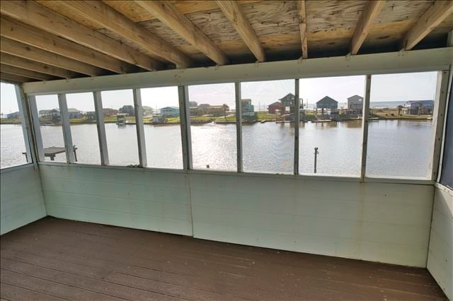 unfurnished sunroom with a water view