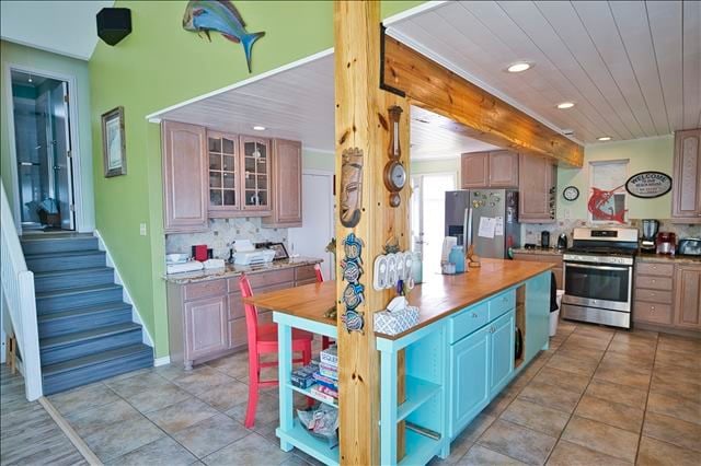 kitchen with stainless steel appliances, wooden ceiling, light tile patterned floors, and backsplash