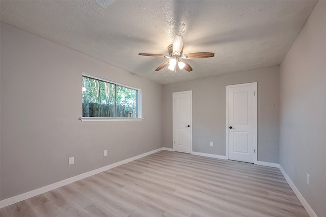 unfurnished room featuring ceiling fan, a textured ceiling, and light wood-type flooring