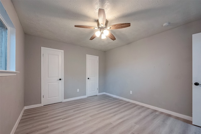 unfurnished bedroom with light hardwood / wood-style floors, a textured ceiling, and ceiling fan