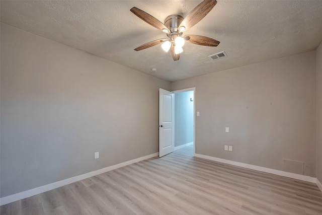 spare room with light hardwood / wood-style floors, ceiling fan, and a textured ceiling