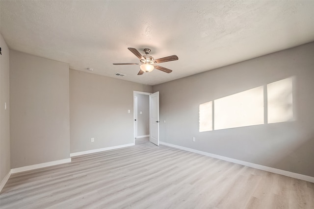 empty room featuring ceiling fan, a textured ceiling, and light hardwood / wood-style floors