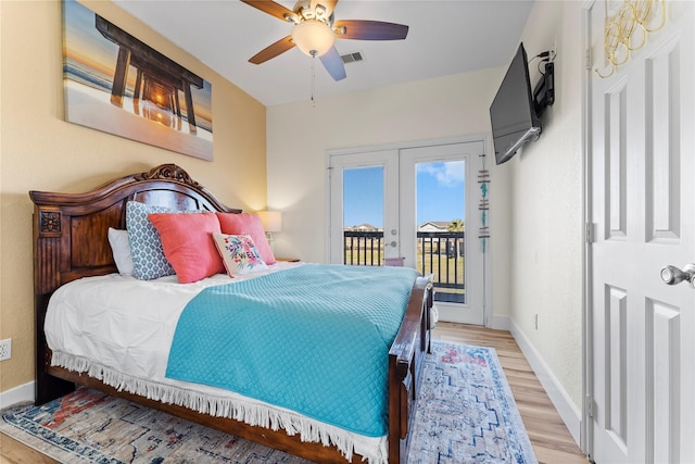 bedroom featuring ceiling fan, light hardwood / wood-style floors, access to exterior, and french doors