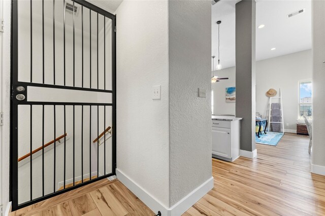 2423 Sandpiper, Crystal Beach, TX 77650 - hall featuring a textured wall, light wood-type flooring, and baseboards