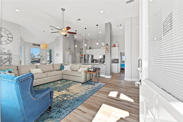 2423 Sandpiper, Crystal Beach, TX 77650 - living room featuring a ceiling fan, a towering ceiling, light wood-style floors, baseboards, and recessed lighting