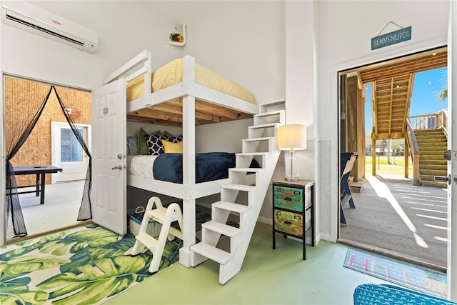 bedroom with high vaulted ceiling, an AC wall unit, and concrete floors