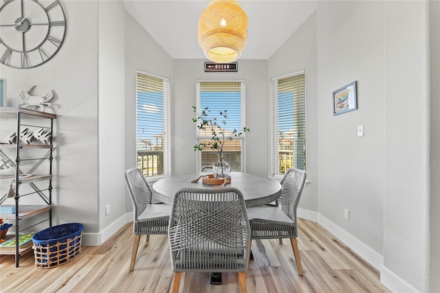 dining space featuring a wealth of natural light, light hardwood / wood-style flooring, and lofted ceiling