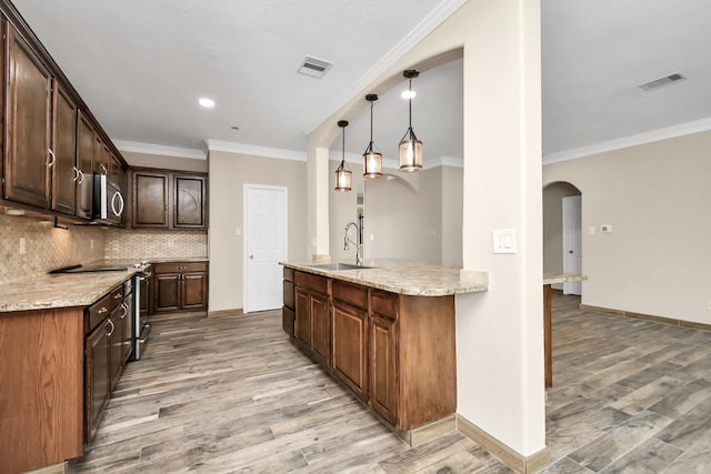 kitchen with hardwood / wood-style floors, light stone counters, sink, and stainless steel appliances