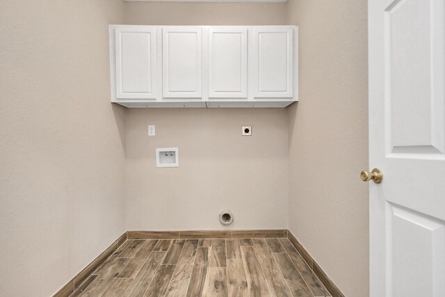 laundry area with washer hookup, electric dryer hookup, dark hardwood / wood-style flooring, and cabinets