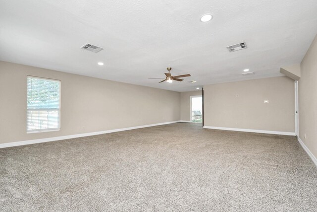 carpeted spare room with ceiling fan and a textured ceiling