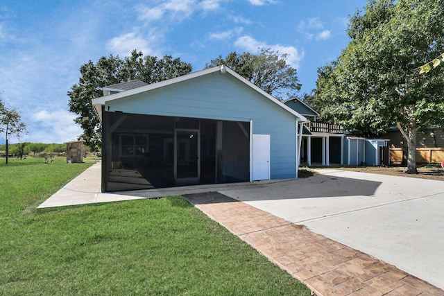 rear view of house featuring a sunroom and a lawn