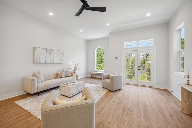 living room featuring ceiling fan, light wood-type flooring, and french doors