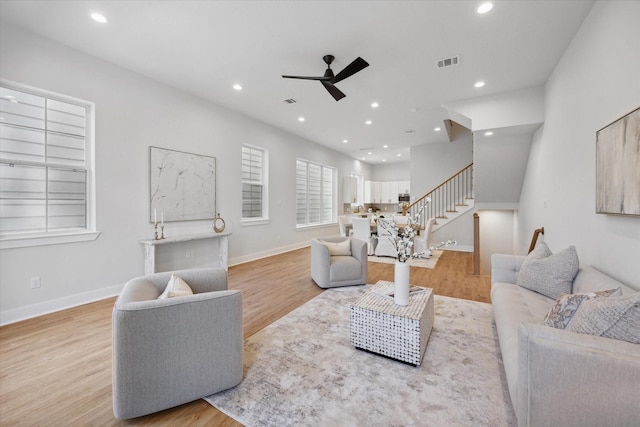 living room featuring ceiling fan and light hardwood / wood-style flooring