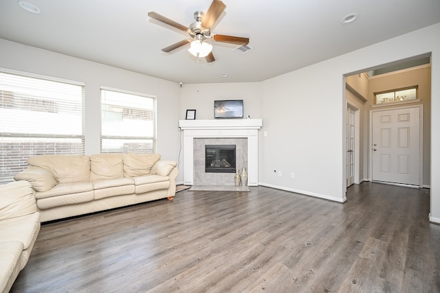 unfurnished living room with dark wood-type flooring, a tile fireplace, and ceiling fan