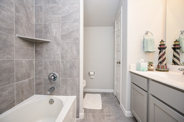 full bathroom featuring tile patterned flooring, vanity, toilet, and tiled shower / bath combo