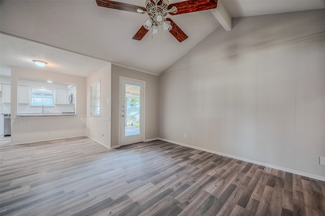 unfurnished living room with lofted ceiling with beams, light hardwood / wood-style floors, ceiling fan, and sink