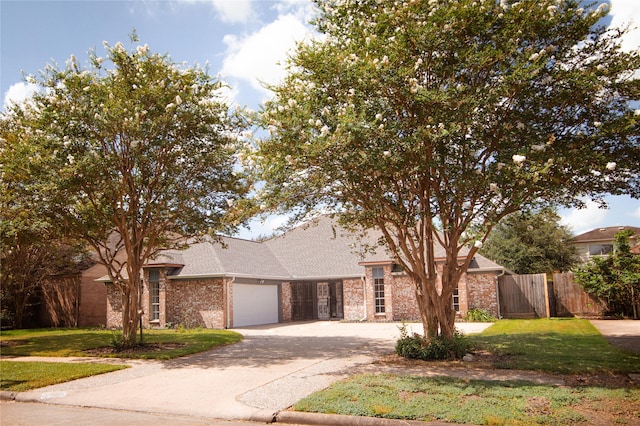 view of front of house with brick siding, concrete driveway, an attached garage, fence, and a front lawn