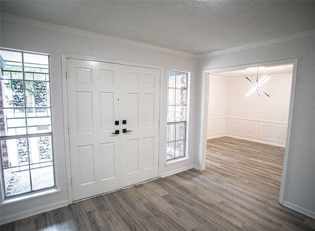 foyer entrance with dark hardwood / wood-style flooring, a textured ceiling, and crown molding