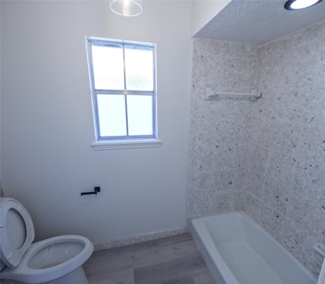 bathroom with toilet, hardwood / wood-style floors, and a bathing tub