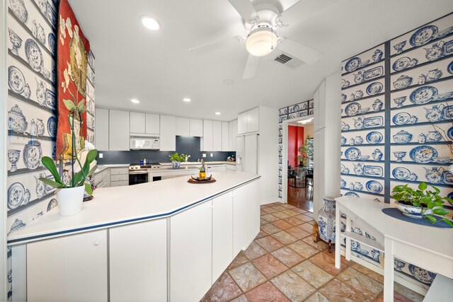 kitchen featuring kitchen peninsula, tasteful backsplash, ceiling fan, electric stove, and white cabinets