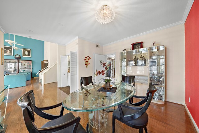 dining space with hardwood / wood-style floors, a notable chandelier, and ornamental molding