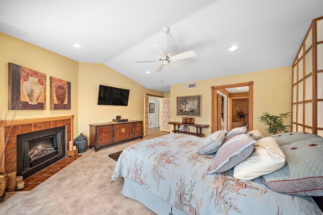 bedroom with carpet flooring, ceiling fan, a fireplace, and vaulted ceiling