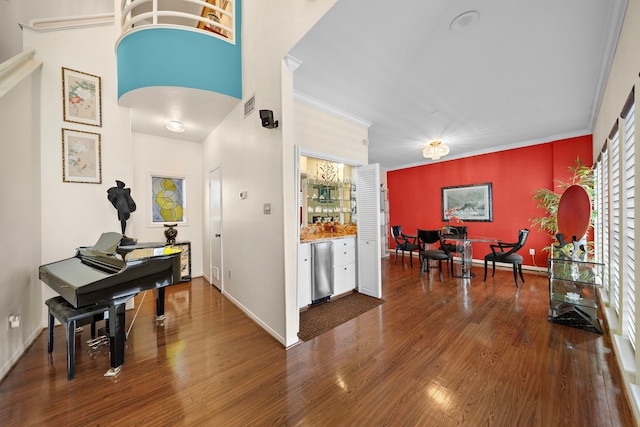 foyer entrance featuring dark wood-type flooring and crown molding