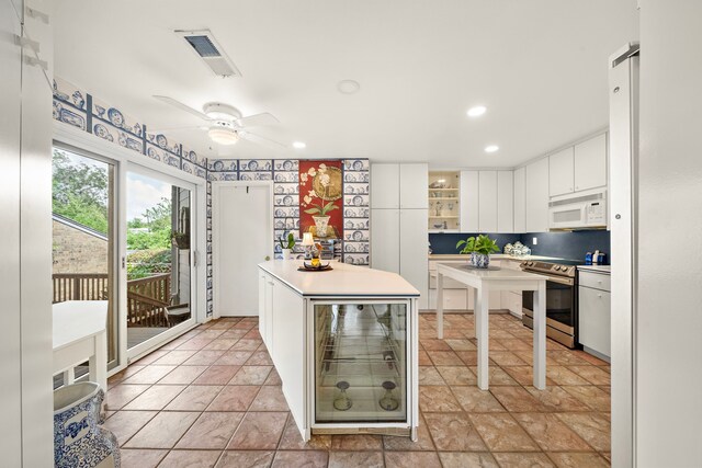 kitchen with electric range, a center island, white cabinets, and wine cooler