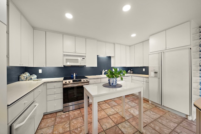 kitchen featuring white appliances and white cabinetry