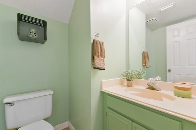 bathroom with toilet, vanity, and a textured ceiling