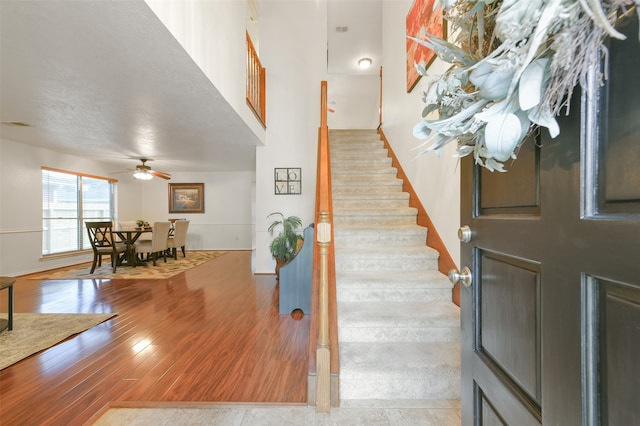 entryway with a textured ceiling, light hardwood / wood-style floors, and ceiling fan