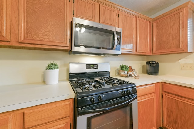 kitchen with gas range oven and a textured ceiling