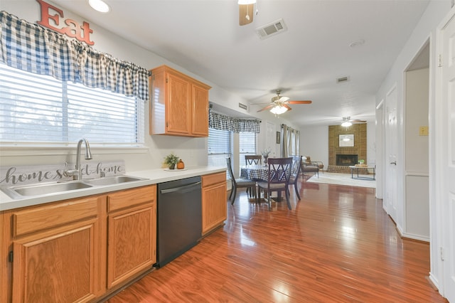 kitchen featuring black dishwasher, hardwood / wood-style flooring, a wealth of natural light, and sink