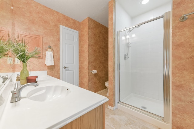 bathroom with a shower with shower door, vanity, toilet, and tile patterned floors