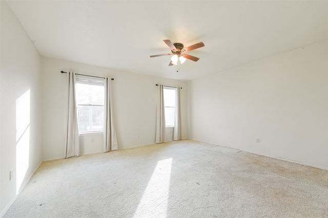 carpeted empty room featuring ceiling fan and plenty of natural light