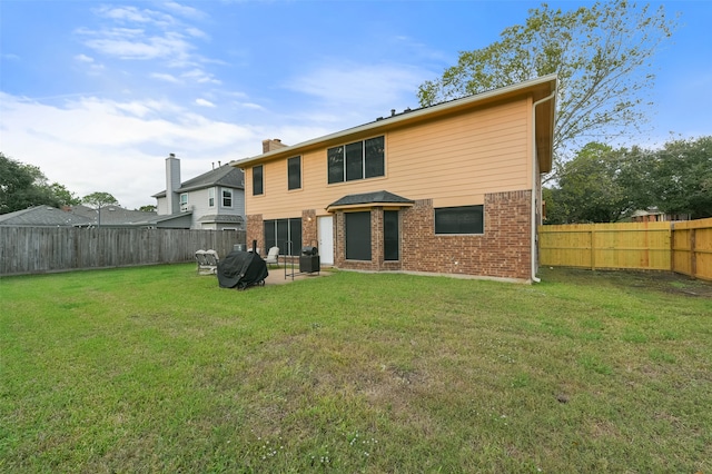 rear view of property with a yard and a patio