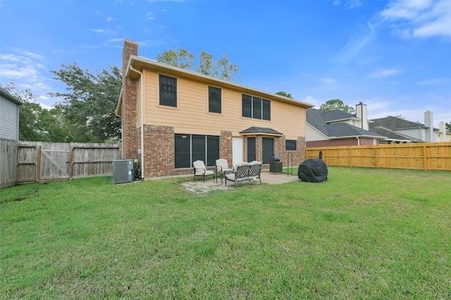 back of house featuring cooling unit, a yard, and a patio area