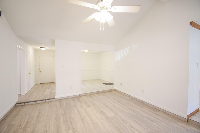 empty room featuring ceiling fan, lofted ceiling, and light wood-type flooring