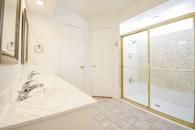 bathroom with tile patterned flooring, vanity, and a shower with door