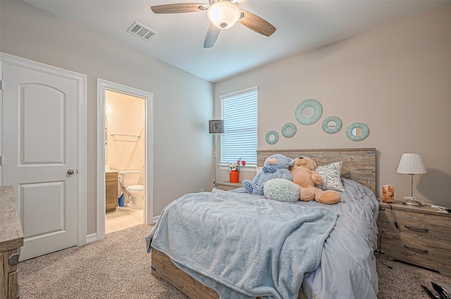 bedroom with ensuite bathroom, light carpet, and ceiling fan