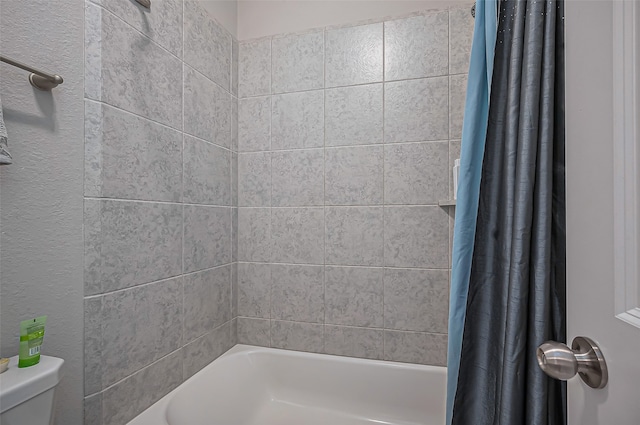 bathroom featuring toilet and shower / tub combo