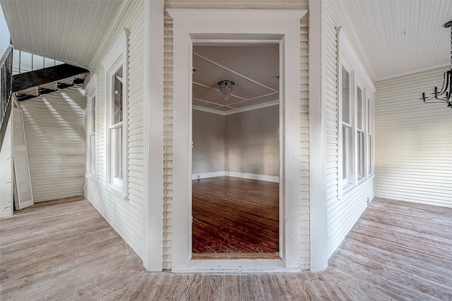 hallway featuring light wood-type flooring and crown molding