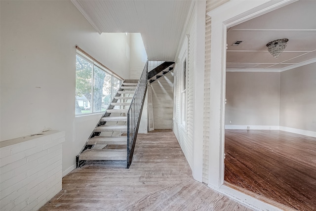 staircase featuring hardwood / wood-style flooring and ornamental molding