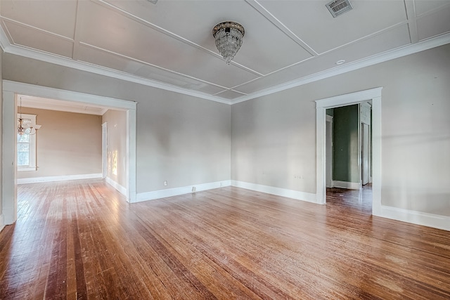 unfurnished room featuring wood-type flooring, crown molding, and an inviting chandelier