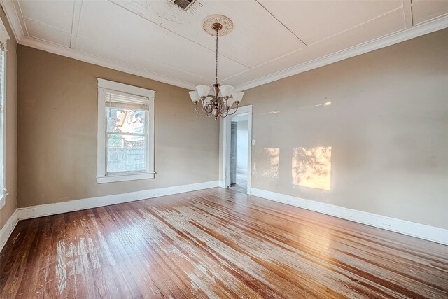 unfurnished dining area featuring a chandelier, crown molding, and wood-type flooring