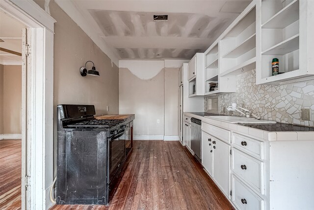 kitchen with dark hardwood / wood-style flooring, stainless steel dishwasher, black range with gas cooktop, sink, and white cabinetry